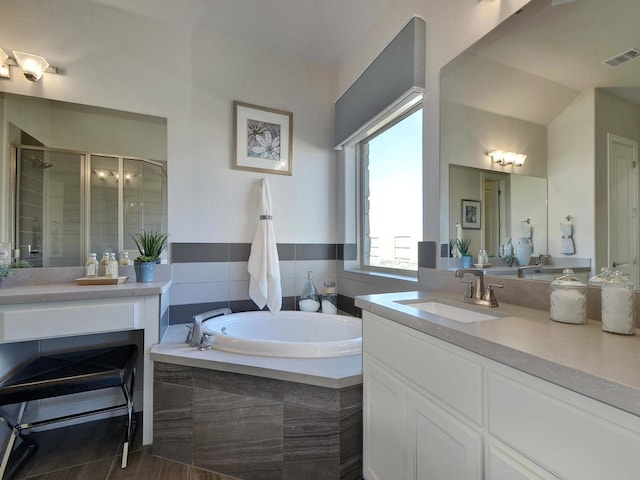 bathroom featuring tile floors, vanity, and shower with separate bathtub