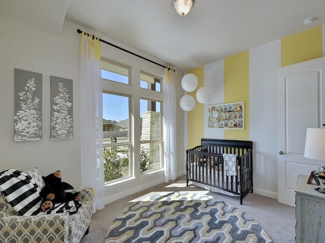 carpeted bedroom featuring a crib