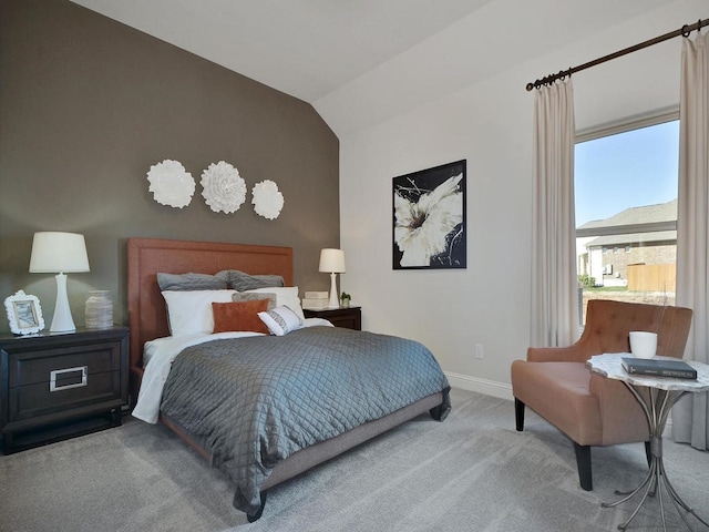 carpeted bedroom with lofted ceiling