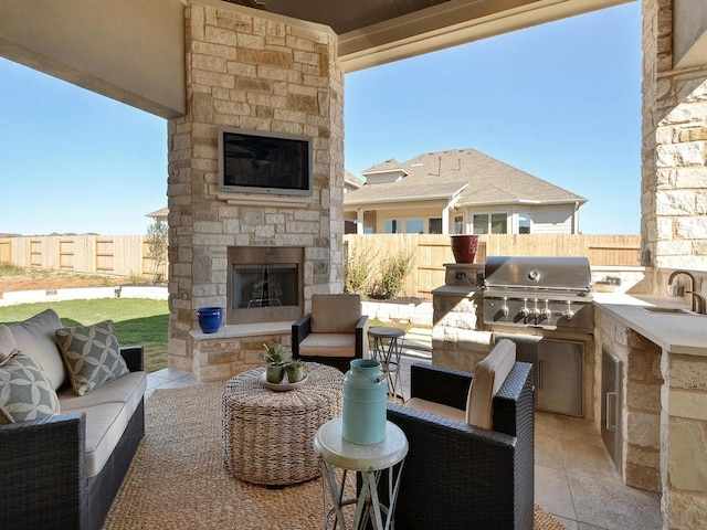 view of patio / terrace featuring exterior kitchen, a grill, and an outdoor living space with a fireplace