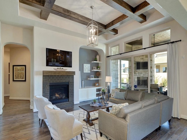 living room featuring coffered ceiling, beam ceiling, dark hardwood / wood-style flooring, and a brick fireplace