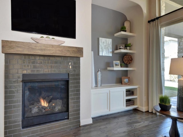 living room featuring a fireplace, dark hardwood / wood-style floors, and built in features