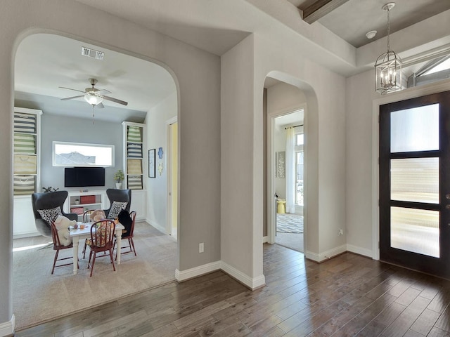 foyer entrance with hardwood / wood-style floors and ceiling fan with notable chandelier