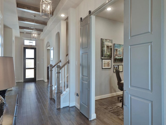 entryway featuring beamed ceiling, a barn door, and dark hardwood / wood-style flooring