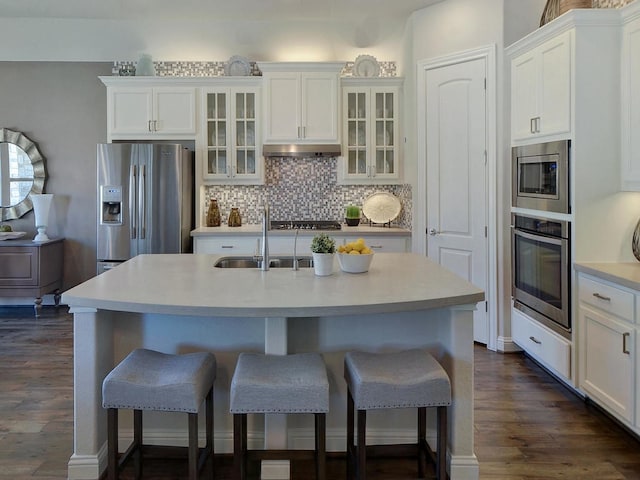 kitchen featuring an island with sink, stainless steel appliances, dark hardwood / wood-style flooring, and sink