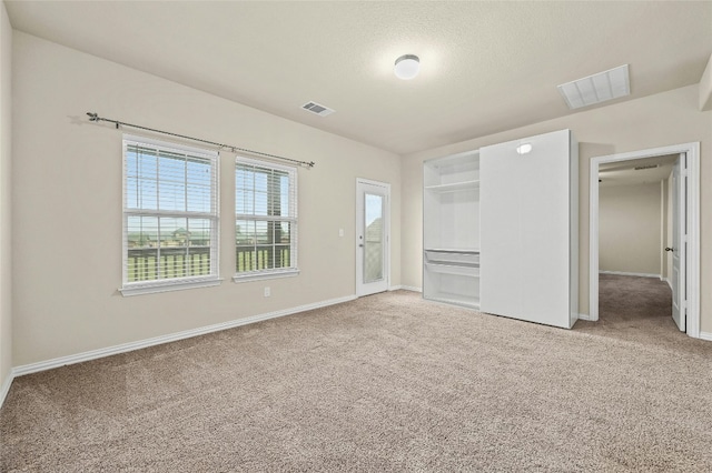 unfurnished bedroom featuring carpet floors and a textured ceiling