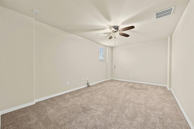 spare room with carpet, a textured ceiling, and ceiling fan