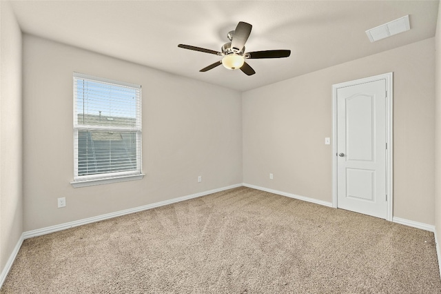 carpeted spare room featuring ceiling fan