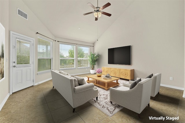 tiled living room with ceiling fan and high vaulted ceiling