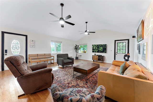 living room with light hardwood / wood-style flooring, lofted ceiling, ceiling fan, and a wealth of natural light