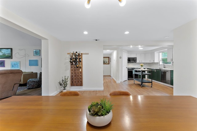 dining room with sink and light wood-type flooring