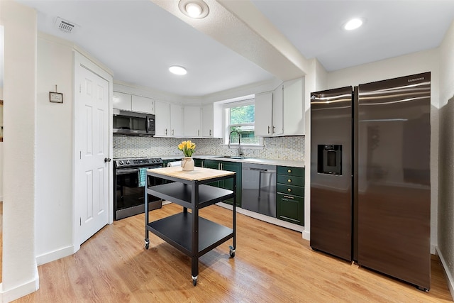 kitchen featuring decorative backsplash, sink, white cabinets, light wood-type flooring, and appliances with stainless steel finishes