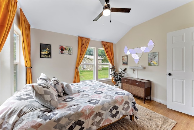 bedroom featuring light hardwood / wood-style flooring, vaulted ceiling, and ceiling fan