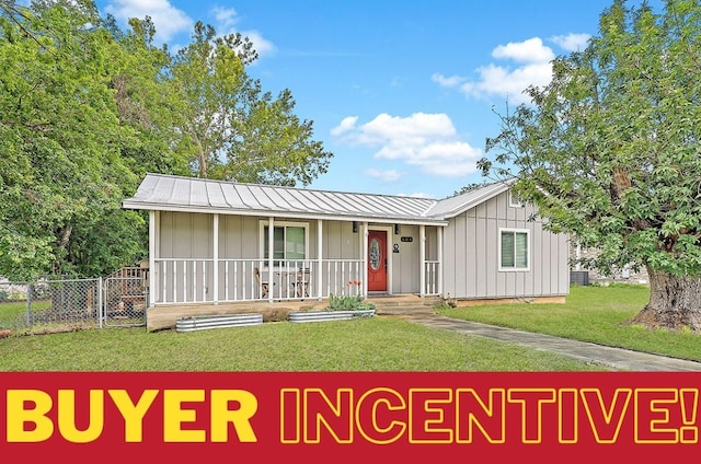 ranch-style home featuring covered porch and a front lawn