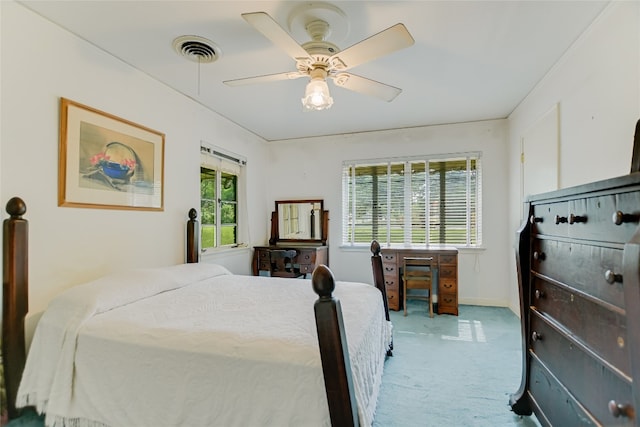 bedroom with ceiling fan, carpet floors, and multiple windows