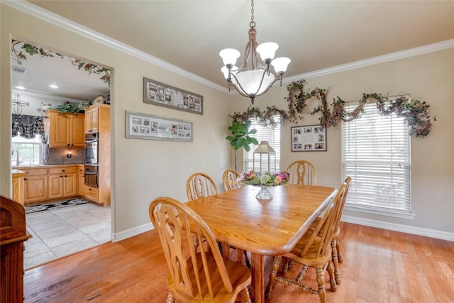 dining area featuring crown molding, a wealth of natural light, and light hardwood / wood-style flooring