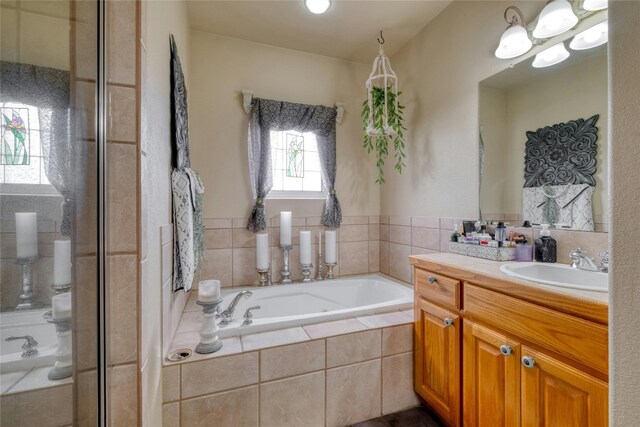 bathroom featuring vanity and tiled tub