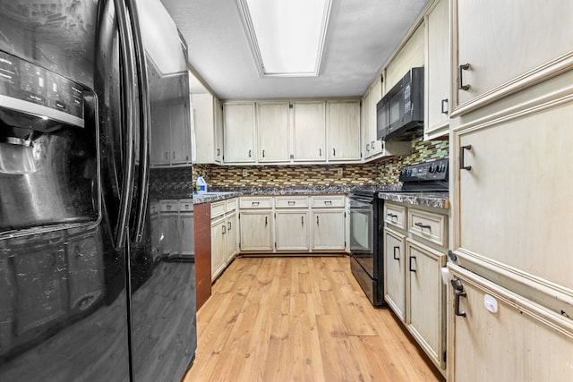 kitchen with cream cabinetry, light hardwood / wood-style floors, tasteful backsplash, and black appliances