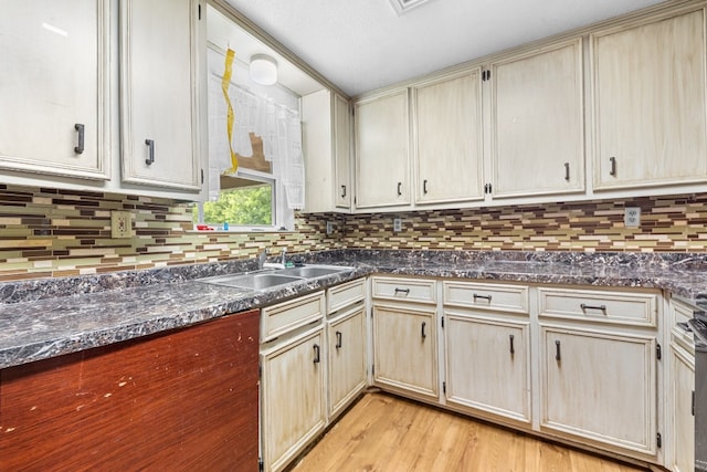 kitchen with sink, backsplash, and light hardwood / wood-style flooring