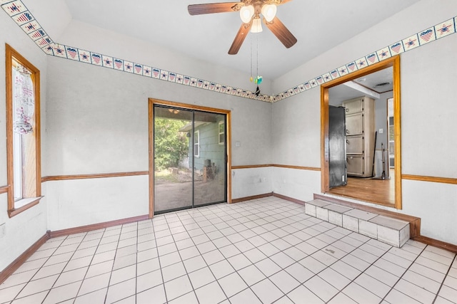 tiled spare room with ceiling fan