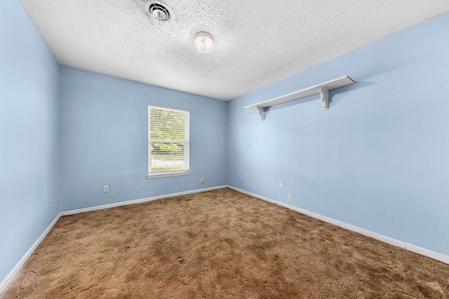 carpeted empty room featuring a textured ceiling