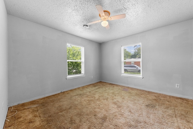 spare room with a textured ceiling, carpet, and ceiling fan