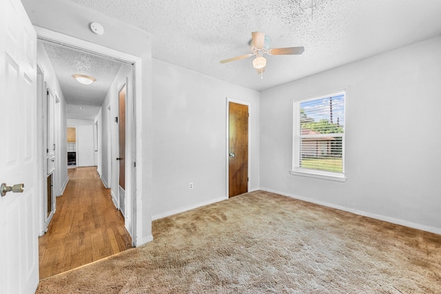 unfurnished bedroom featuring a textured ceiling, carpet, and ceiling fan