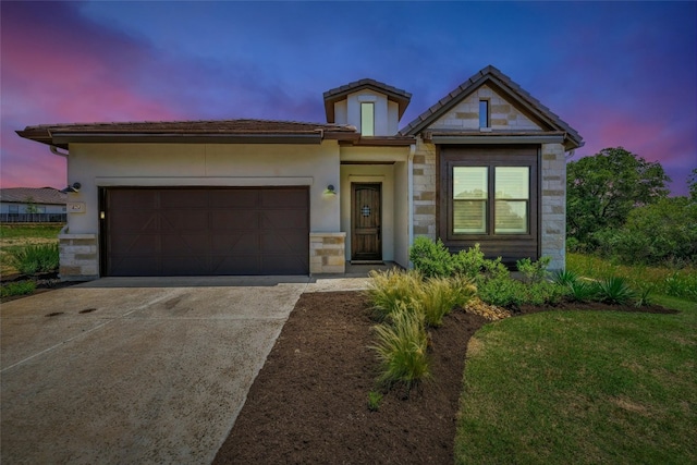 view of front of home with a garage and a lawn