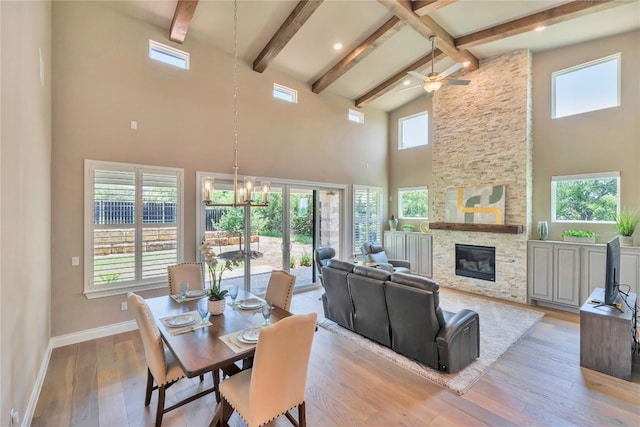 dining room with ceiling fan with notable chandelier, a wealth of natural light, and light wood-type flooring