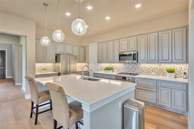 kitchen featuring light hardwood / wood-style floors, sink, a kitchen island with sink, and stainless steel appliances