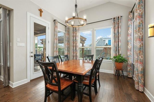 dining space with vaulted ceiling, dark wood-type flooring, and an inviting chandelier