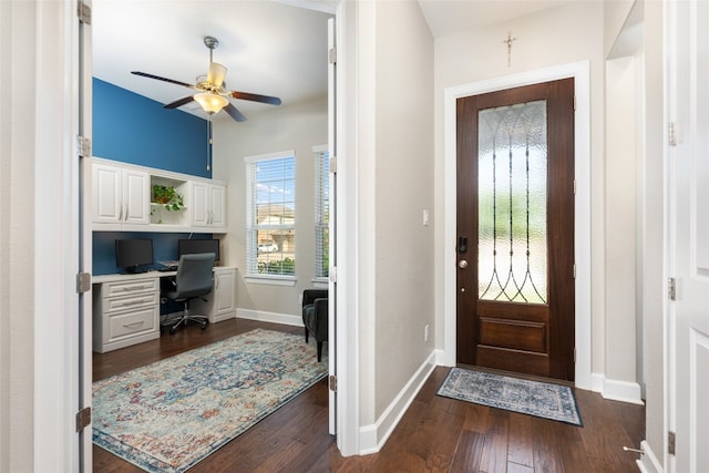 foyer with dark hardwood / wood-style flooring, ceiling fan, and built in desk