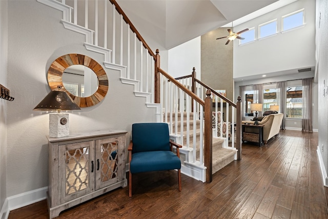 stairway featuring ceiling fan, plenty of natural light, a towering ceiling, and hardwood / wood-style flooring