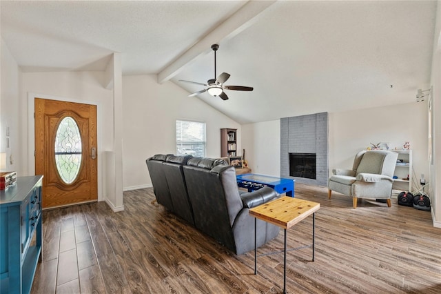 living room with lofted ceiling with beams, dark hardwood / wood-style floors, a brick fireplace, and plenty of natural light