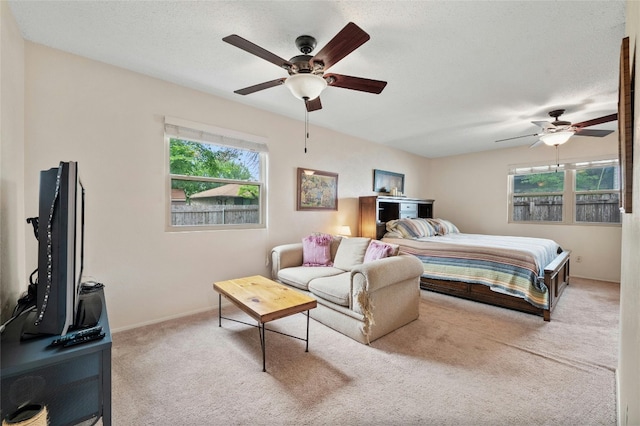 carpeted bedroom featuring a textured ceiling and ceiling fan