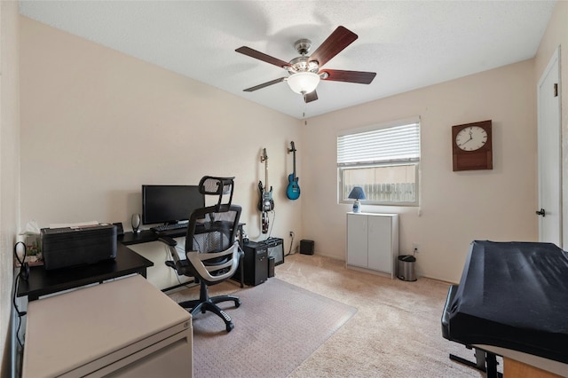 carpeted office featuring ceiling fan and a textured ceiling