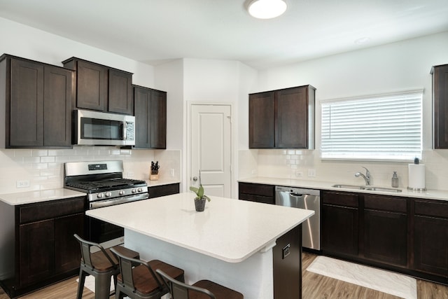 kitchen featuring a breakfast bar area, dark brown cabinets, sink, and stainless steel appliances