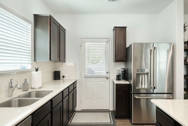 kitchen with tasteful backsplash, sink, stainless steel appliances, and dark brown cabinetry