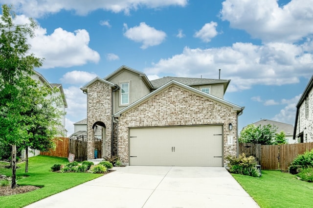 traditional-style house with stucco siding, concrete driveway, a front yard, fence, and a garage