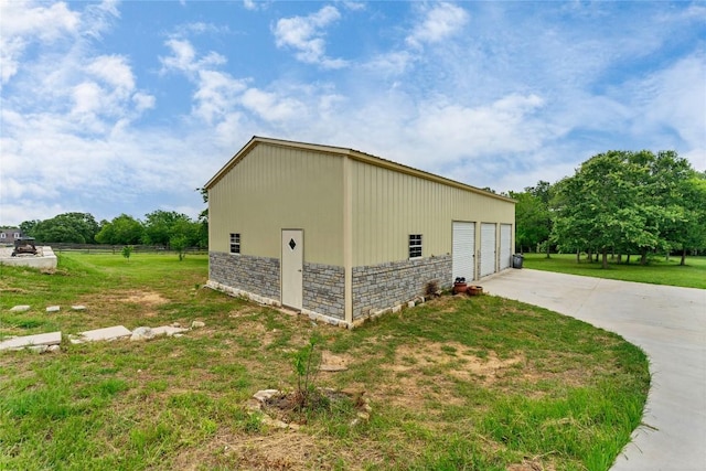 view of property exterior featuring a yard, a pole building, stone siding, a garage, and an outdoor structure