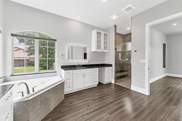 bathroom featuring plus walk in shower, hardwood / wood-style floors, and vanity