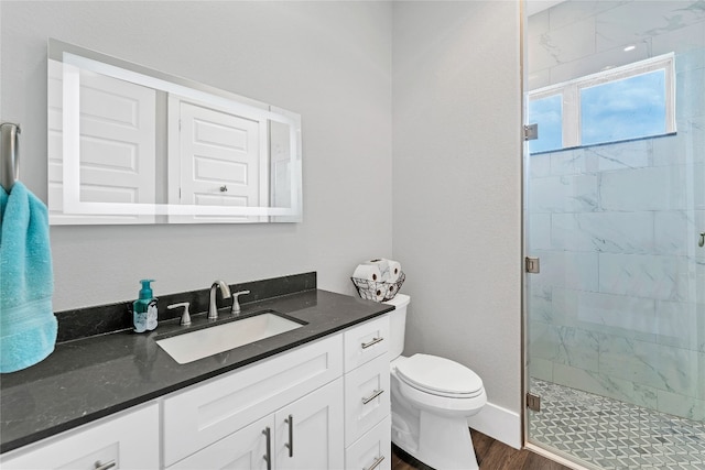 bathroom featuring hardwood / wood-style floors, vanity, a shower with door, and toilet