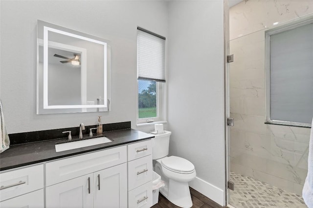 full bathroom with vanity, baseboards, toilet, a shower stall, and wood finished floors