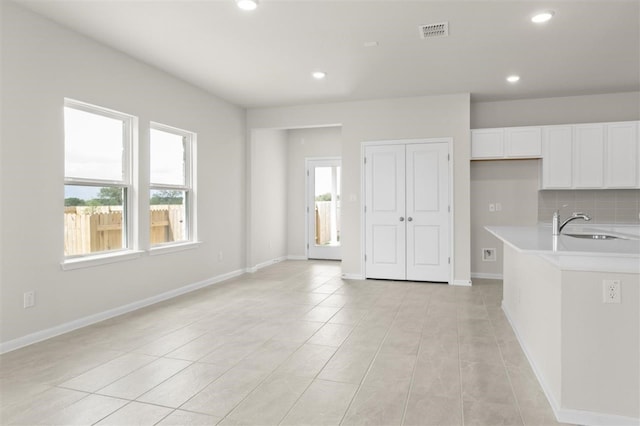 kitchen featuring white cabinets, light tile patterned flooring, and sink