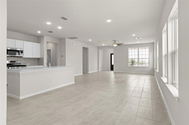 kitchen with white cabinets, sink, ceiling fan, light tile patterned flooring, and stainless steel appliances