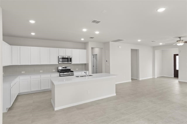 kitchen featuring white cabinetry, sink, ceiling fan, a kitchen island with sink, and appliances with stainless steel finishes