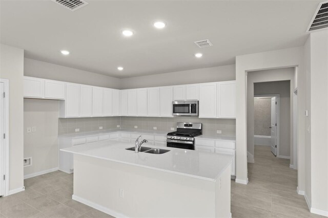 kitchen featuring sink, white cabinetry, a kitchen island with sink, and appliances with stainless steel finishes