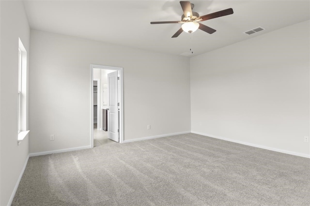 spare room featuring ceiling fan and light colored carpet