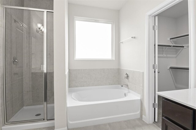 bathroom with vanity and separate shower and tub