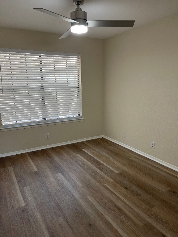 spare room with ceiling fan and dark wood-type flooring